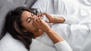Woman experiencing sinus infection symptoms in NYC
